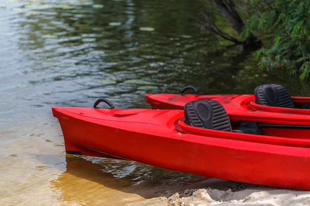 Zwei rote Kajaks am Strand.