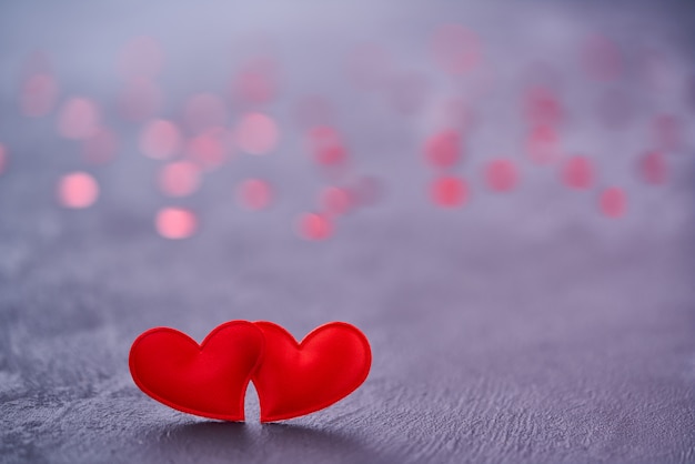 Zwei rote Liebesherzen berühren sich. Paar rote Herzen als Symbol der Liebe