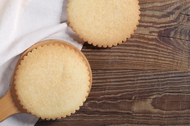 Zwei runde Lebkuchen auf Schneidebrett und Stoff befinden sich auf einem Holztisch, Nahaufnahme, Draufsicht mit Platz für Text