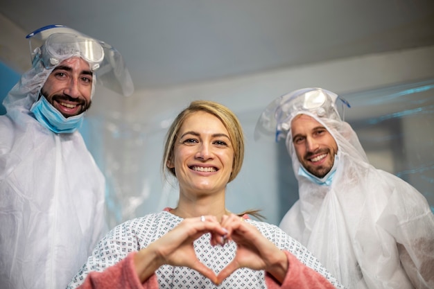 Zwei Ärzte überwachen den kranken Patienten. Das Mädchen macht das Herz Liebessymbol.