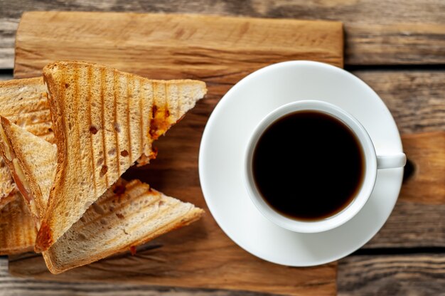 zwei Sandwiches und Kaffee auf einem Holzhintergrund