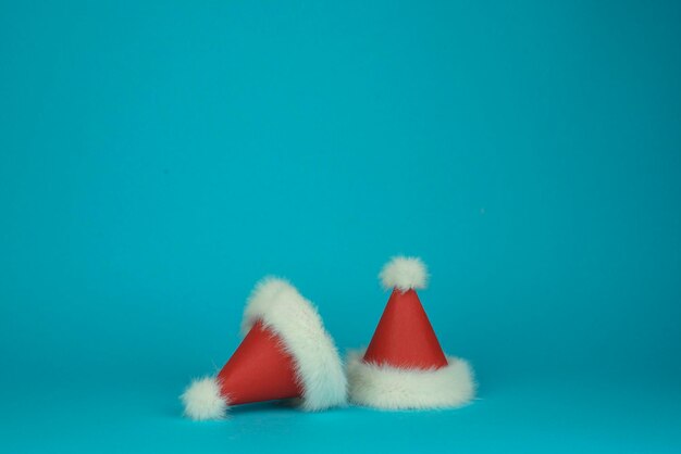 Foto zwei santa clauss rot mit weißen federhüten auf blauem hintergrund minimal-stil-karte