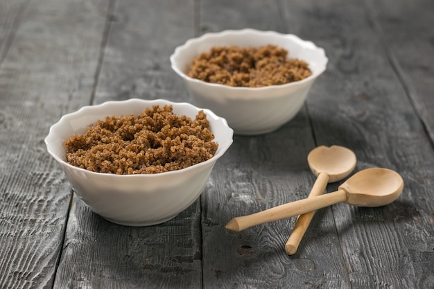 Zwei Schalen Brei Quinoa mit Schokolade und Holzlöffeln