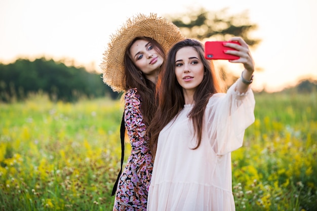 Zwei schöne europäische Mädchen machen ein Selfie im Freien