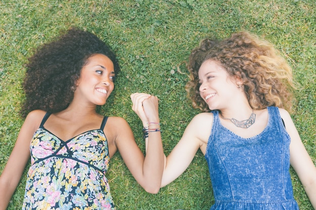 Zwei schöne Frauen, die auf dem Gras liegen