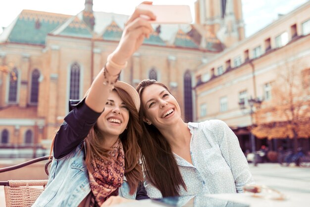 Zwei schöne Frauen, die sich im Café selbst machen