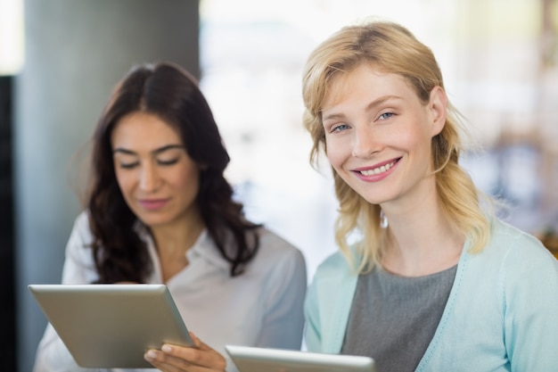 Foto zwei schöne frauen mit digitalem tablet