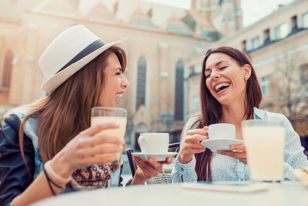 Zwei schöne junge Mädchen, die in einem Café sitzen