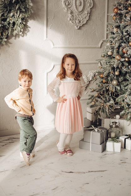 Zwei schöne Kinder in der Nähe des Weihnachtsbaumes