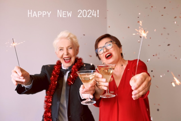Zwei schöne, stilvolle, reife Seniorinnen feiern das neue Jahr. Feierlichkeiten im Fun-Party-Stil
