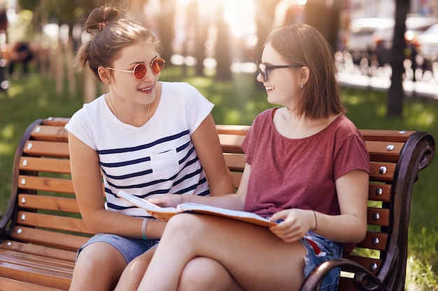 Zwei schöne Studentinnen tragen Sommerfarben