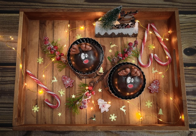 Zwei Schokoladenhirsche in einem Holztablett mit Weihnachtsdekor auf dem Tisch