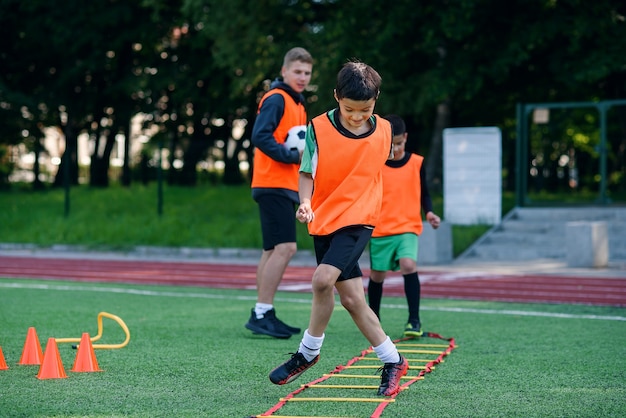 Zwei Schuljungen führen während des Fußball-Sommercamps Leiterübungen durch.