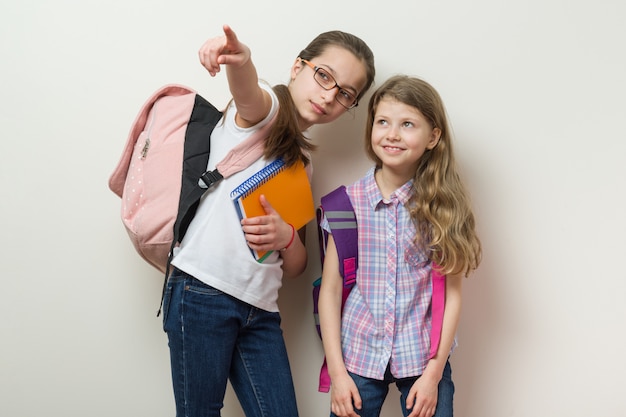 Zwei Schulkinder stehen mit Rucksäcken