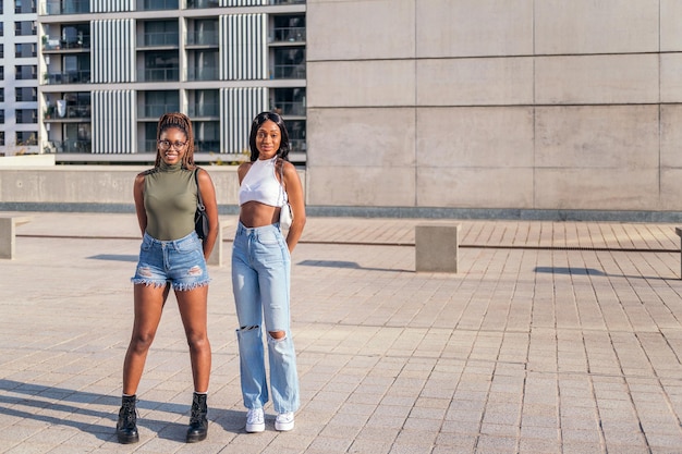 Zwei schwarze Freundinnen stehen im Freien und schauen in die Kamera, Konzept der Freundschaft und des urbanen Lebensstils, kopieren Platz für Text