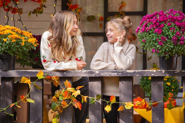 zwei Schwestern zusammen im Herbst feiern und Spaß haben an Halloween in der Nähe des Hauses Familienportrai