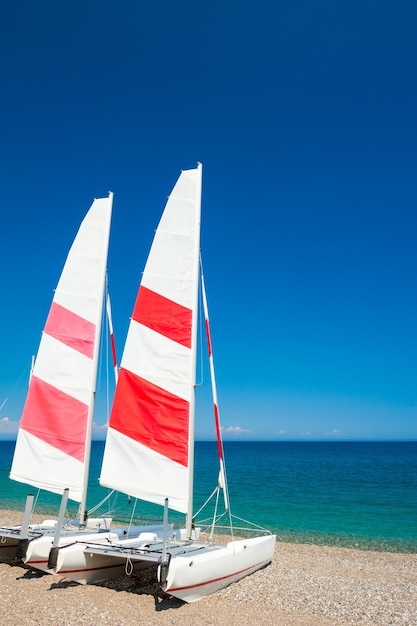 Zwei Segelkatamarane am Strand von Kemer, Türkei. Reisen und Urlaub