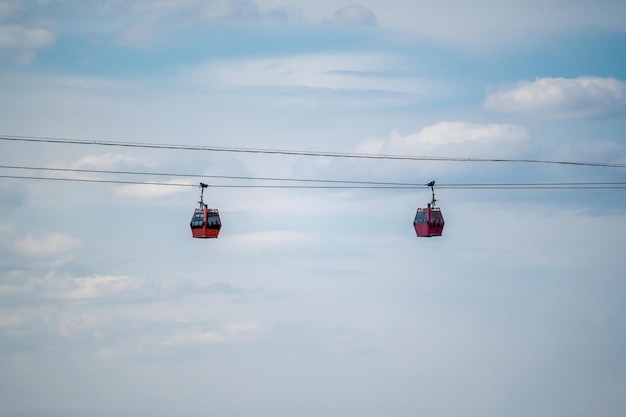 Zwei Seilbahnen hoch im Himmel Seilbahn als Transportmittel in modernen Städten Seilbahn vor bewölktem Himmelshintergrund