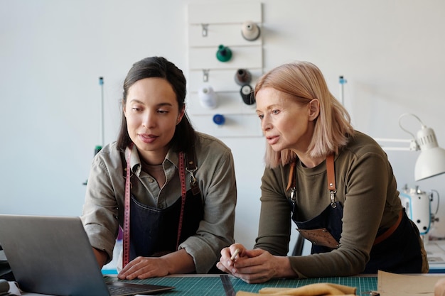 Zwei selbstbewusste Kollegen in Arbeitskleidung diskutieren über neue Modetrends