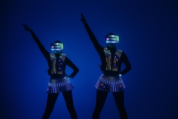 Zwei sexy Disco-Tänzerinnen bewegen sich in UV-Kostümen. Partys und Tänze.