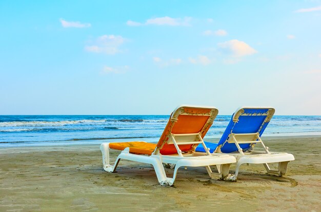 Zwei Sonnenliegen am Sandstrand