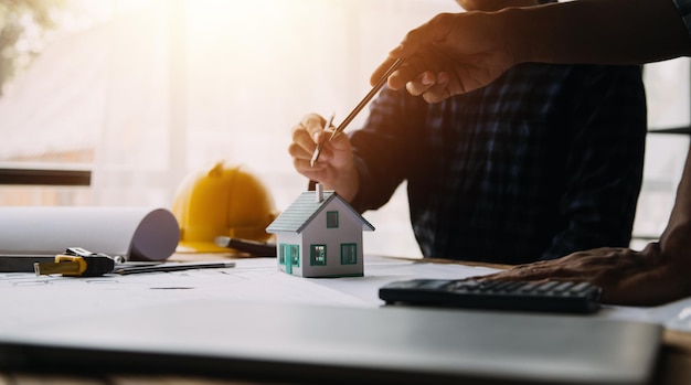 Zwei Spezialisten inspizieren ein gewerbliches Industriebau-Immobilienprojekt mit einem Bauingenieur, einem Investor und einem Laptop im Hintergrund. Kran-Wolkenkratzer-Betonschalungsrahmen