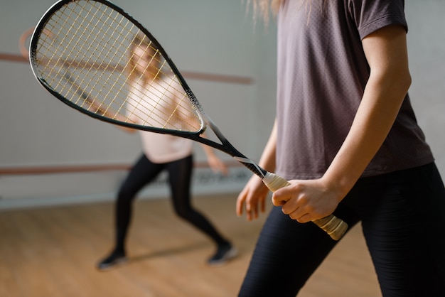 Zwei Spielerinnen mit Schlägern, Squashspiel