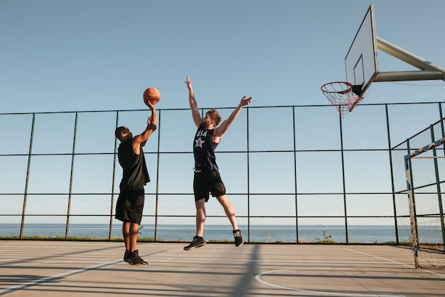 Zwei Sportler spielen Basketball auf dem Spielplatz