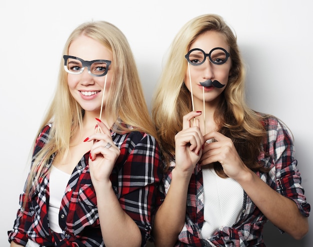 Zwei stilvolle sexy Hipster-Mädchen beste Freunde bereit für die Party, über grauem Hintergrund