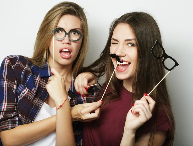 Zwei stilvolle sexy Hipster-Mädchen beste Freunde bereit für die Party, über grauem Hintergrund