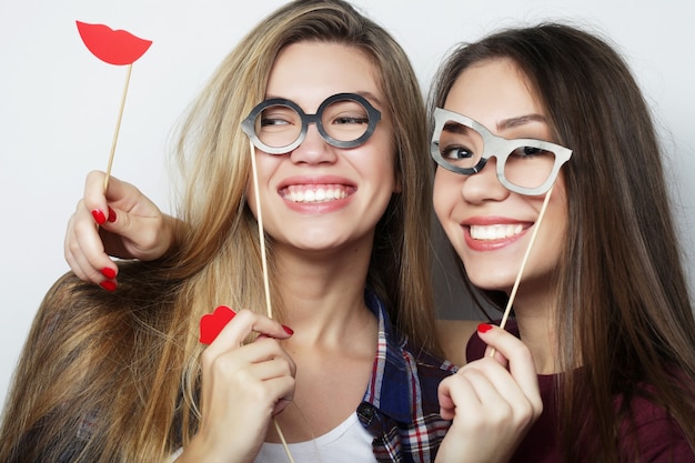 Zwei stilvolle sexy Hipster-Mädchen beste Freunde bereit für die Party, über grauem Hintergrund