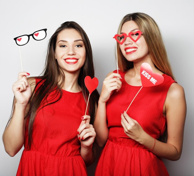 Zwei stilvolle sexy Hipster-Mädchen beste Freunde bereit für die Party, über grauem Hintergrund