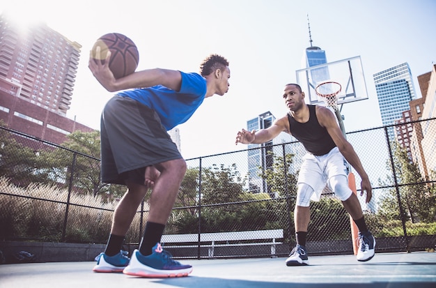 Zwei Straßenbasketballspieler spielen hart auf dem Platz