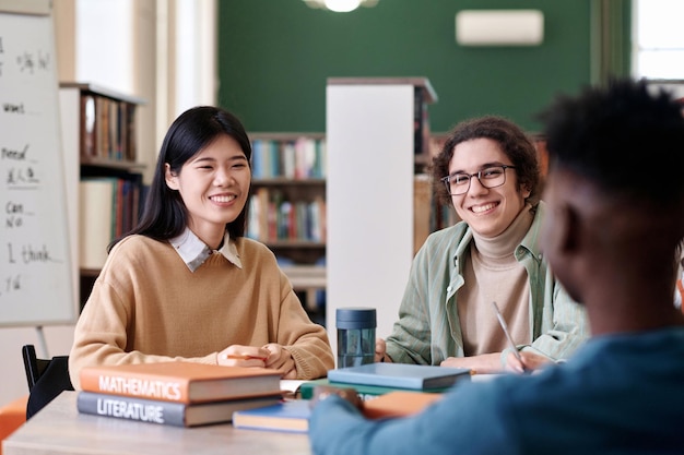 Zwei Studenten lachen glücklich in der Bibliothek