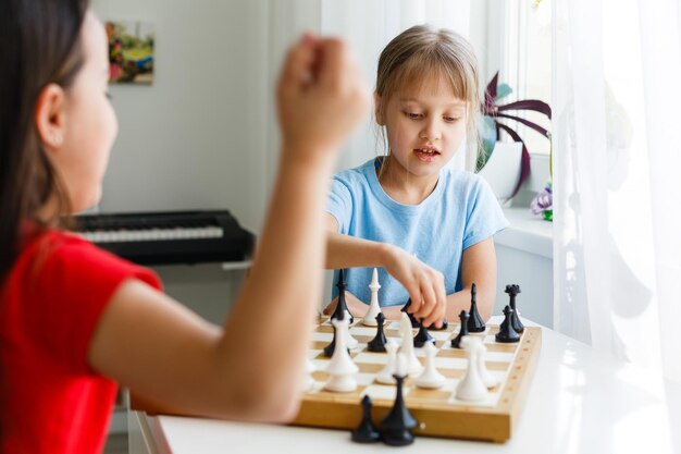 Zwei süße Kinder, die zu Hause Schach spielen