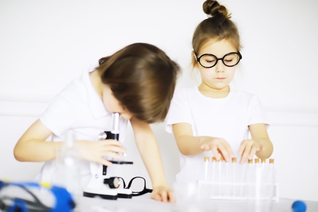 Zwei süße Kinder im Chemieunterricht machen Experimente auf weißem Hintergrund