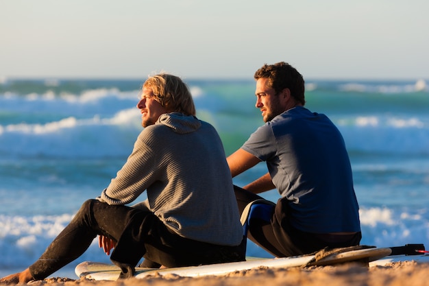 Zwei Surfer am Strand sprechen