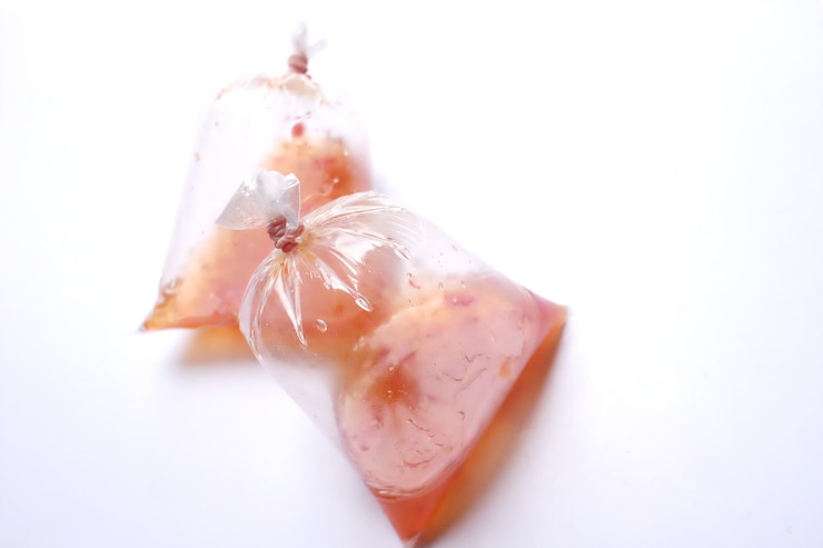 Foto zwei taschen mit roten hühner-dipping-saucen auf weißem hintergrund