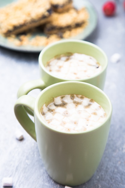 Zwei Tasse heißen Kaffee oder Schokolade und Kuchen mit Marshmallow. Nahansicht.