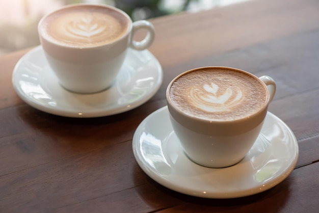 Zwei Tassen Art Latte oder Cappuccino auf Holztisch