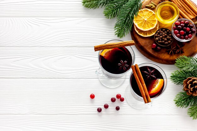 Zwei Tassen Glühwein, Gewürze und trockene Zitrusfrüchte wärmen das Weihnachtsgetränk