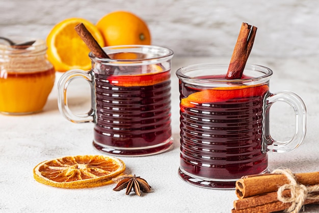 Zwei Tassen heißer Glühwein auf grauem Hintergrund