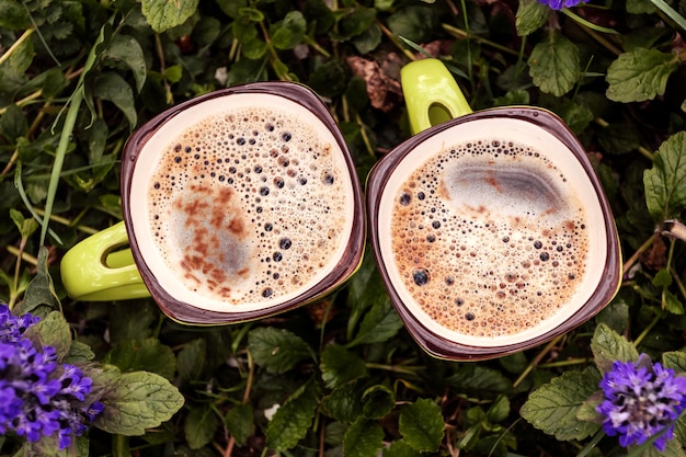 Zwei Tassen Kaffee in Blüte. Draußen. Platz für Text.