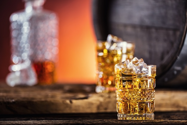 Zwei Tassen voller Getränke Whisky Brandy oder Cognac mit Eiswürfeln im Retro-Stil
