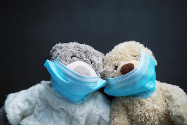 Zwei Teddybären mit Schutzmaske. Coronavirus Schutz. Spielzeugbär in Maske, um die Ausbreitung von Viren zu verhindern. Platz kopieren.