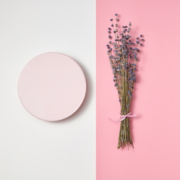 Zwei teile der kreativen karte mit rundem rahmen und natürlichem öko-bündel von lavendelblumen auf einer duotonen hellgrauen und rosa wand, kopierraum.