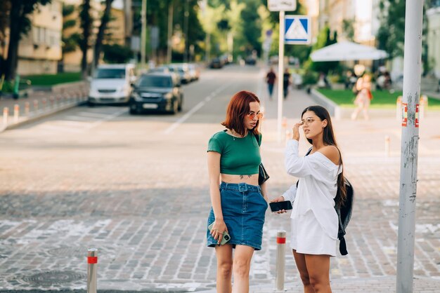 Zwei Touristenfreunde konsultieren einen Online-Guide auf einem Smartphone auf der Straße