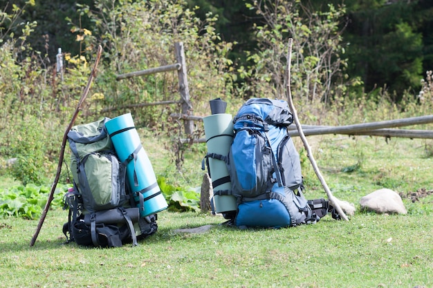 Zwei touristische Wandererrucksäcke, die in einem Gebirgstal am sonnigen Tag stehen