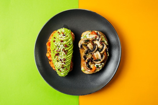 Zwei vegetarische Frühstücksbrötchen mit Pilzen und Avocado