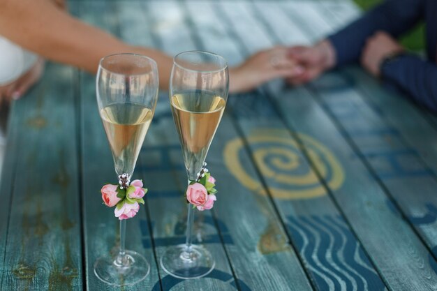 zwei verzierte Gläser mit Champagner auf dem Tisch am Hochzeitstag. Ort der Feier.